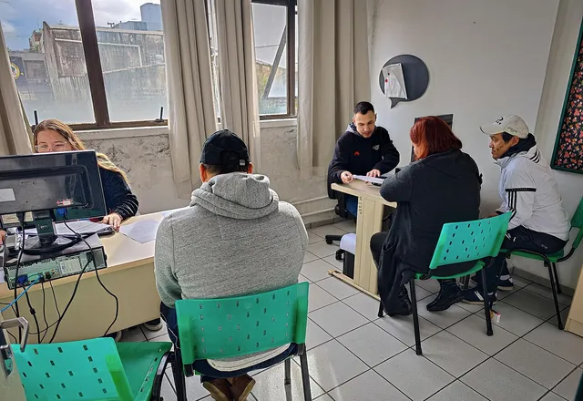 Equipe atendendo várias pessoas ao mesmo tempo num serviço de assistência social